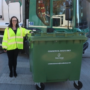 A square green bin with four wheels