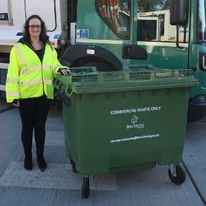 A square, green bin with four wheels