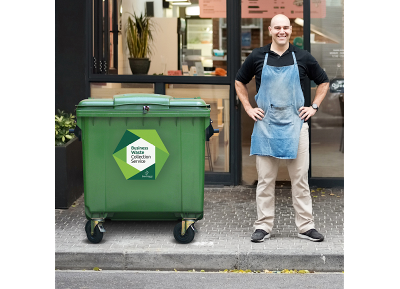 Local business owner in Breckland standing beside a food waste collection bin with Business Waste Collection Service label